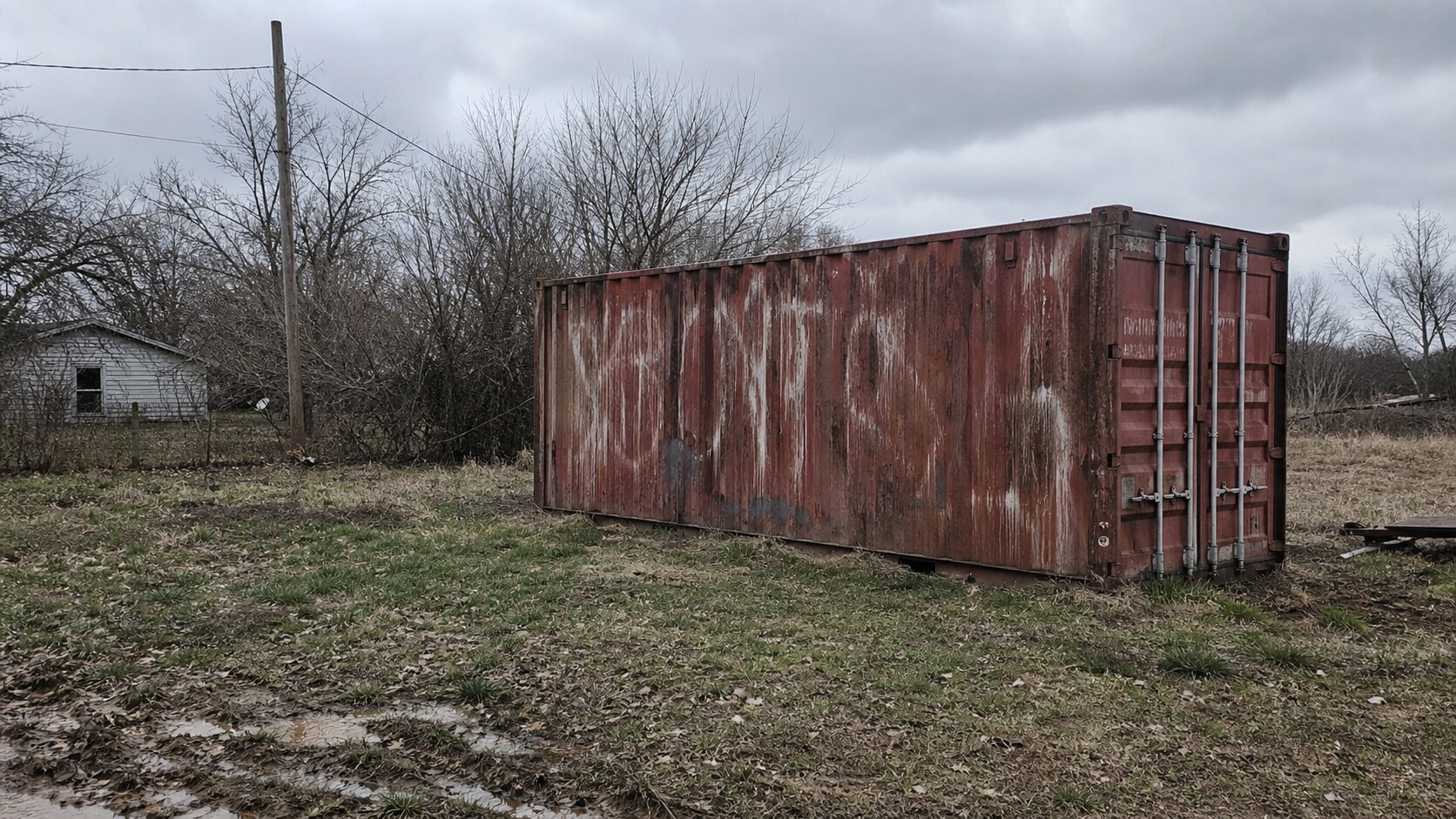 A rusted shipping container in a rural yard evokes the Jamison family's reported relocation plans and fears.