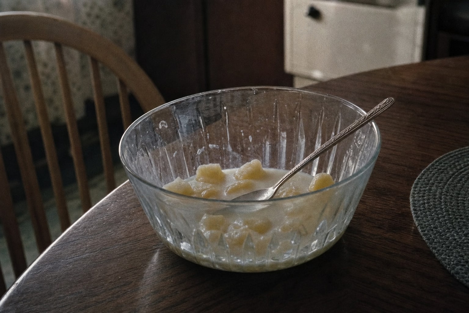 A glass bowl with pineapple and milk remnants on a kitchen table, representing the disputed Ramsey timeline evidence.