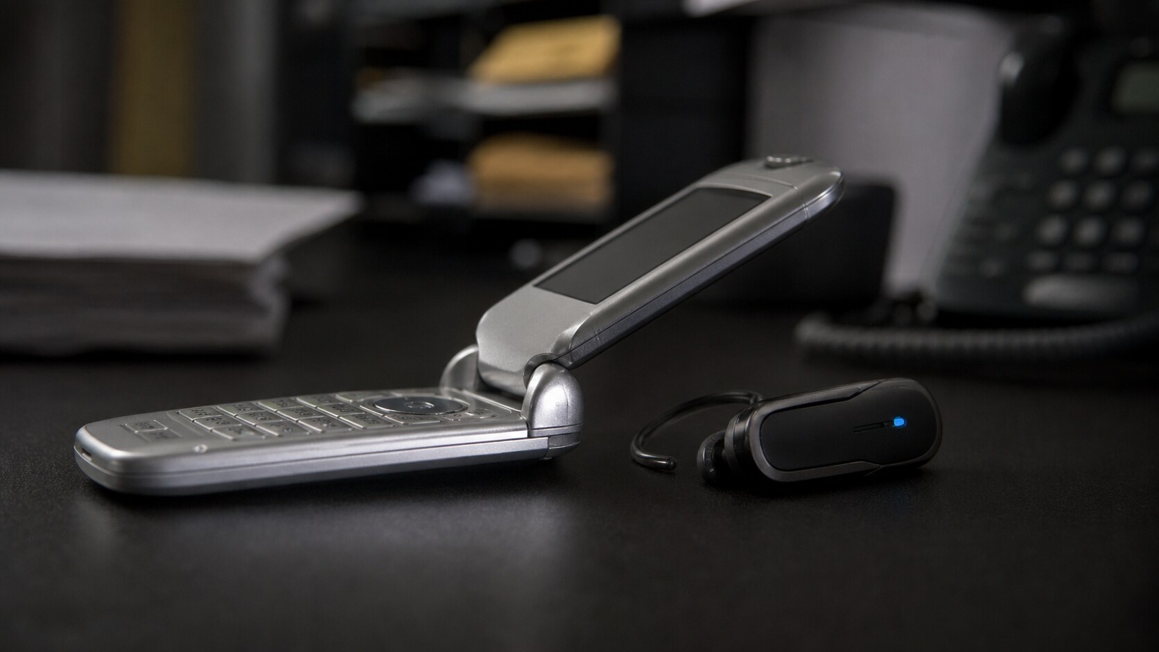 A silver flip phone and Bluetooth earpiece evoke Rhoda McFarland's emergency call during the Lane Bryant murders.