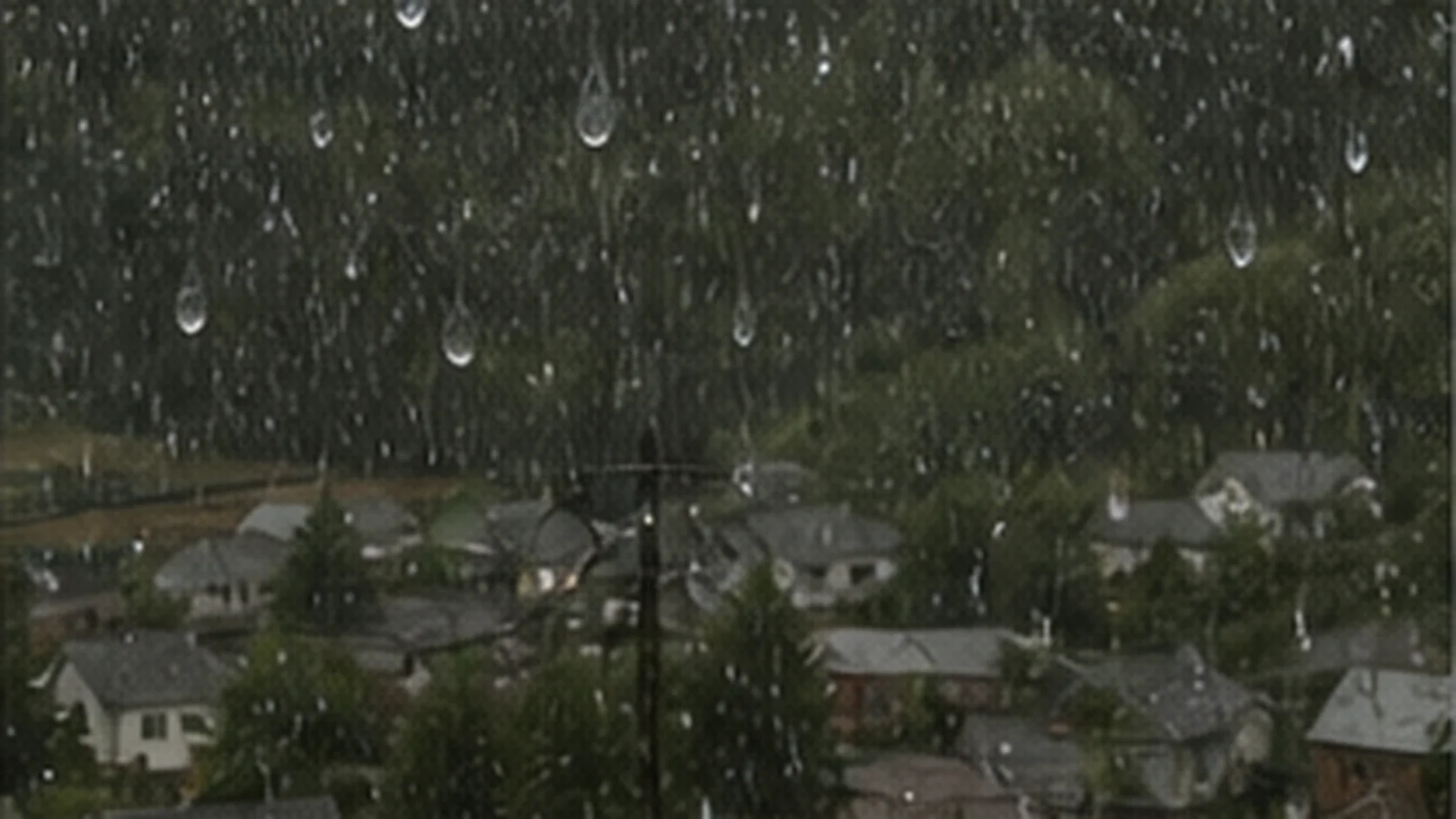 Translucent jelly-like droplets falling with rain over a small Pacific Northwest town