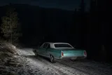 A turquoise and white Mercury Montego-style coupe abandoned on a snowy Plumas mountain road, representing the Yuba County Five case.