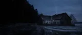 Isolated 1922 Bavarian farm at blue hour with a smoking chimney and a dark forest path