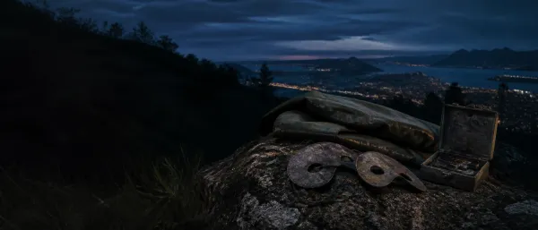 Two crude lead eye masks and a raincoat on Morro do Vintém above Niterói at blue hour
